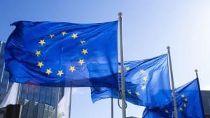 Drei Flaggen der Europäischen Union wehen an einem sonnigen Tag im Wind.