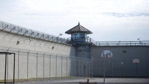 Blick von innen auf Gefängnismauern mit einem Wachturm